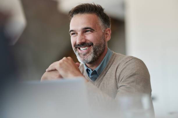 Happy male entrepreneur day dreaming while working in the office.